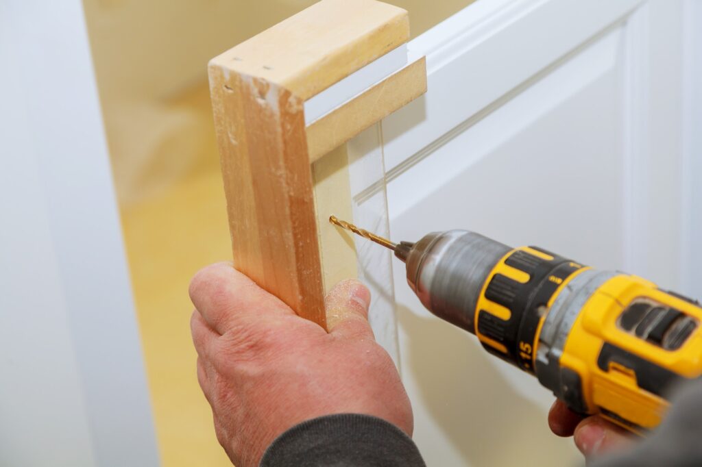 Installation of furniture hinges on the cabinet door master drills the door in the cabinet door